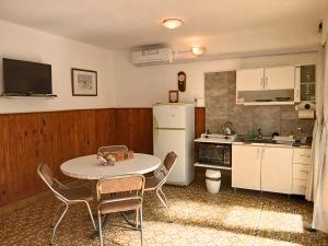 a kitchen with a table and chairs and a white refrigerator at Depto 1615 in Villa Mercedes