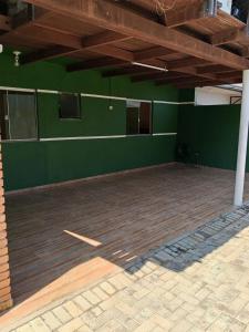 an empty room with green walls and a wooden floor at Seu lar em Cascavel in Cascavel