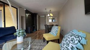 un soggiorno con un divano, sedie e un tavolo di Oceana Suites Los Maticos a Llanquihue