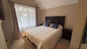 una camera da letto con un letto grande e una grande finestra di Oceana Suites Los Maticos a Llanquihue