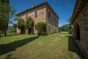 una vista exterior de un edificio de piedra con patio en Belvedere - Falceto, Ambra, Toscana, en Ambra