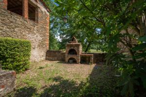 Un edificio de ladrillo con un horno en un patio. en Belvedere - Falceto, Ambra, Toscana, en Ambra