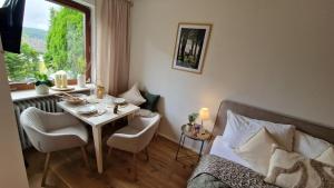 a living room with a table and a small table and chairs at Cozy Schwarzwaldnest für 2! in Schönwald