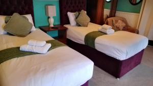 a hotel room with two beds with towels on them at Kings Head Hotel in Kirkbymoorside