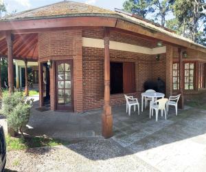 a pavilion with a table and chairs on a patio at CHALET ENTRE PINOS IDEAL PARA 4 HUESPEDEs in Costa del Este