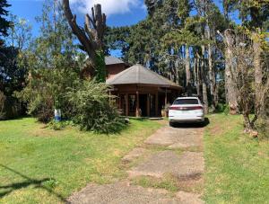 a car parked in front of a house at CHALET ENTRE PINOS IDEAL PARA 4 HUESPEDEs in Costa del Este