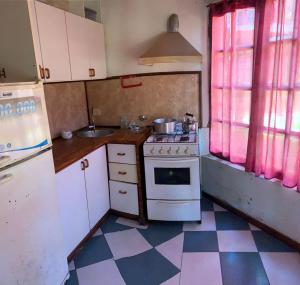 a small kitchen with a stove and a sink at CHALET ENTRE PINOS IDEAL PARA 4 HUESPEDEs in Costa del Este
