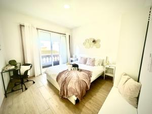 a bedroom with a bed and a desk and a window at Vilaflor Suit Dreams by Deihu Experiences in Vilaflor