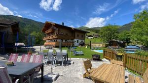 eine Terrasse mit einem Tisch und Stühlen sowie ein Haus in der Unterkunft Unterdacheben in Dienten am Hochkönig