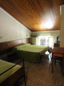 a bedroom with a green bed and a wooden ceiling at Albergo Delle Alpi in Miroglio