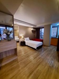 a hotel room with a bed and a large room at Baan Tanwa - MRT Ratchadapisek Exit 1 or 2 in Bangkok