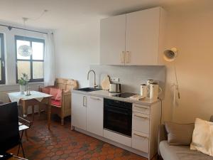 una cucina con armadi bianchi, divano e tavolo di Landhaus Schmitt a Sommerach