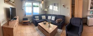 a living room with a blue couch and a table at Seestr 75 a Haus A links in Zingst