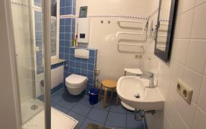 a blue and white bathroom with a toilet and a sink at Seestr 75 a Haus A links in Zingst +8 photos