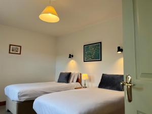 zwei Betten in einem Zimmer mit offener Tür in der Unterkunft Atlantic View Cottages in Doolin