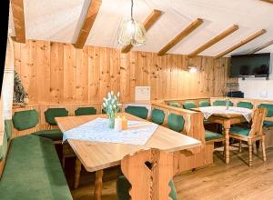 ein Esszimmer mit Holztischen und grünen Stühlen in der Unterkunft Unterdacheben in Dienten am Hochkönig