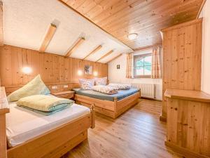zwei Betten in einem Zimmer mit Holzwänden in der Unterkunft Unterdacheben in Dienten am Hochkönig + 47 Fotos