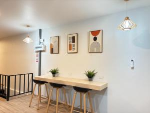 a kitchen with a table and stools against a wall at City Pause Hostel in Sathani Bang Su