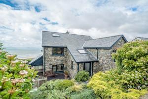 een stenen huis met een zwart dak bij Ty-Mari in Harlech