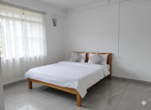 En eller flere senge i et værelse på RK Phura Homestay