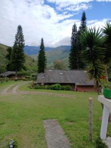 una casa in un campo con montagne sullo sfondo di Cabaña Villa La Morena a Yumbo