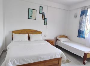 En eller flere senge i et værelse på RK Phura Homestay