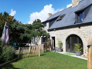 a stone house with a fence and a yard at La Longère d'Arzoù Chambres D'hôtes in Mériadec
