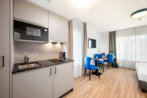 阿旺什Hine Adon Avenches - A2的酒店客房设有厨房、桌子和椅子。