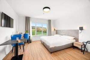 阿旺什Hine Adon Avenches - A2的一间带床、桌椅的酒店房间