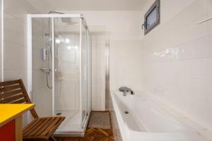 Un baño blanco con ducha y bañera. en Gîte du 17 - bien-être avec spa, en Trans