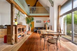 Una sala de estar con una mesa y sillas de madera. en Gîte du 17 - bien-être avec spa, en Trans