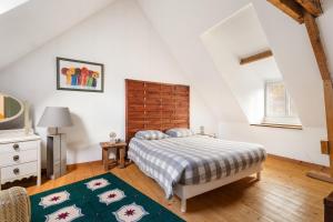 Un dormitorio con una cama y un cabecero de madera. en Gîte du 17 - bien-être avec spa, en Trans