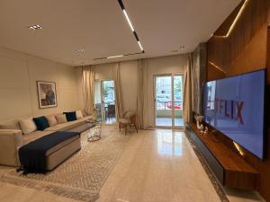 a living room with a large flat screen tv at 2BR at The Boulevard Nest Pool - Gym - Café Vibes in New cairo