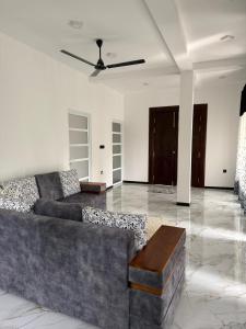 a living room with a couch and a ceiling fan at Sanu Dreams House in Kamburugamuwa