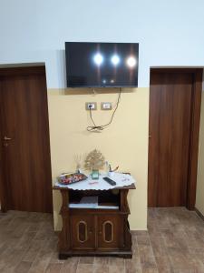 a room with a table with a tv on the wall at Casa Vacanze da Nonna Chiarina in Anagni