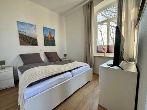 a bedroom with a bed and a flat screen tv at Heuler beim Ochsenturm am Deich in Dingen