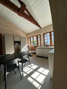 a kitchen with a table and chairs in a room at Le Refuge du Pyla in La Teste-de-Buch