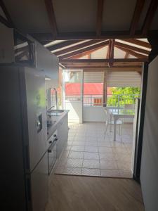 a kitchen with an open door to a patio with a table at Villa Lolyka in Terre-de-Haut +4 photos