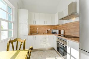 una cucina con mobili bianchi, un tavolo e una finestra di Bungalow atalaya ad Abades