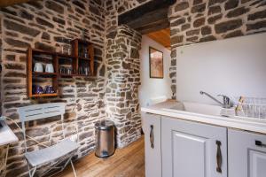 eine Küche mit Spüle und Steinwand in der Unterkunft Gîte du 17 - sauna jacuzzi hammam in Trans + 18 Fotos