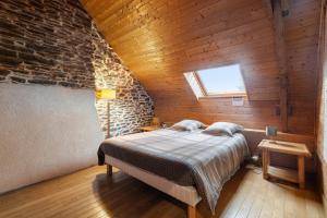 ein Schlafzimmer mit einem Bett und einer Ziegelwand in der Unterkunft Gîte du 17 - sauna jacuzzi hammam in Trans