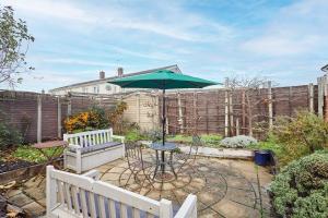 a patio with a table and a green umbrella at Host & Stay - Riders Rest in Wootton