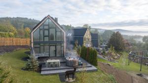 une maison avec un foyer dans l'arrière-cour dans l'établissement FlowFort - Karkonosze View & Spa & Wellness, à Wojcieszyce