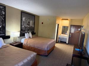 a hotel room with two beds and a bathroom at Coratel Inn and Suites By Jasper Wichita North in Wichita