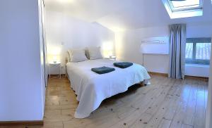 a bedroom with a white bed with two towels on it at Appartements à Dax - 4 min du Centre-Ville, 12 min de la Gare - Arrivée autonome in Dax