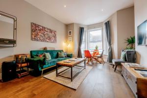 a living room with a green couch and a table at Sandy Bay - Mins To Margate Main Sands in Margate