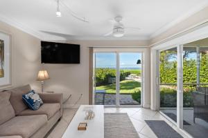 a living room with a couch and a sliding glass door at Beach Castle Resort #3 in Longboat Key
