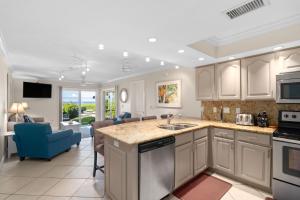 a kitchen with white cabinets and a blue chair at Beach Castle Resort #3 in Longboat Key