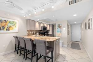 a kitchen with a large island with bar stools at Beach Castle Resort #3 in Longboat Key
