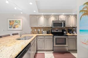 a kitchen with white cabinets and a sink at Beach Castle Resort #3 in Longboat Key
